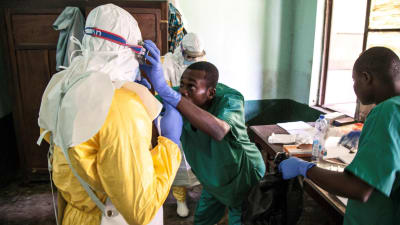 Hälsovårdare iklädd skyddsdräkt förbereder sig på att undersöka patienter som kan ha smittats av ebola. Sjukhus i Bikoro 13.5.2018. 