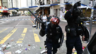Maskerad polisman med batong i Hongkong.