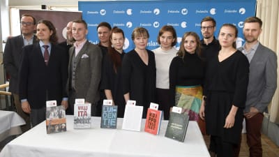 Kandidaterna för Fack-finlandiapriset 2019 står på rad bakom ett bord med deras böcker.