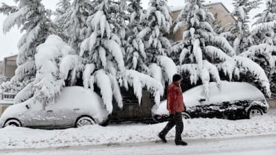 Man promenerar i snö norrom Thessaloniki i Grekland. 