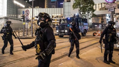 Poliser med batonger på gata i Hongkong.