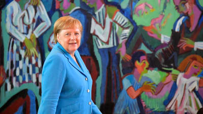 Angela Merkel framför en färgrann målning i Berlin 3 juli 2019.