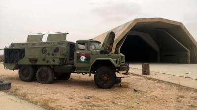 Ett övergivet militärfordon står utanför en hangarbyggnad