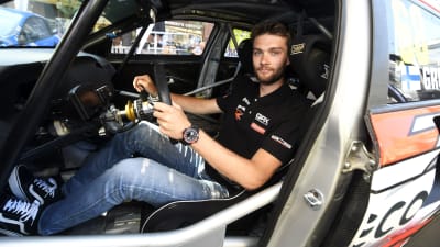 Niclas Grönholm sitter bakom ratten i sin rallycrossbil och tittar mot kameran.
