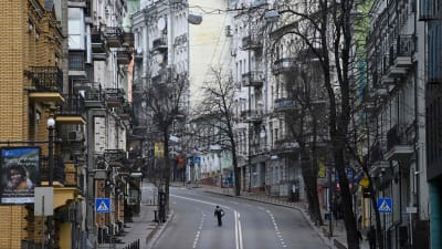 En ensam person går mitt på en öde gata i central Kiev fredagen den 25 februari 2022.