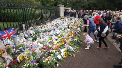 Människor lämnar blommor vid Windsor Castle i London för att hedra minnet av drottning Elizabeth II.