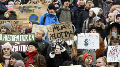 Unga håller upp demonstrationsplakat under klimatstrejk i Helsingfors. 