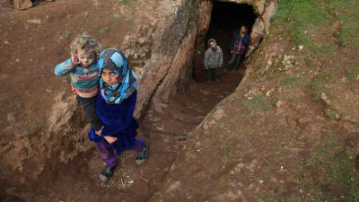 Flyktingar från Aleppo och Idlib kommer ut från en underjordisk skyddsgrotta i Taltunah, ca 15 km nordväst om Idlib i Syrien 23.2.2020