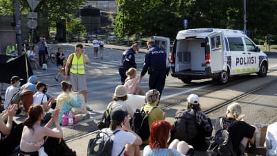 Polisen bär bort demonstranter vid Mannerheimvägen i Helsingfors. 