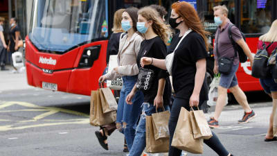 Människor i munskydd går på Oxford Street i London.