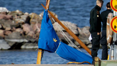 Bild av masten på den segelbåt som var med i olyckan.  Masten är av brunt trä och är sned och sprucken och storseglet inpackat i blå presenning.