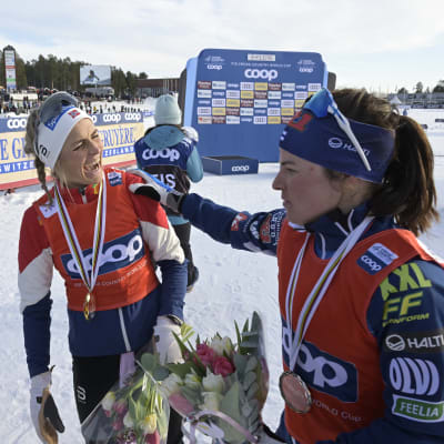 Frida Karlsson, Therese Johaug ja Krista Pärmäkoski normaalimatkojen cupin palkintojenjaossa.