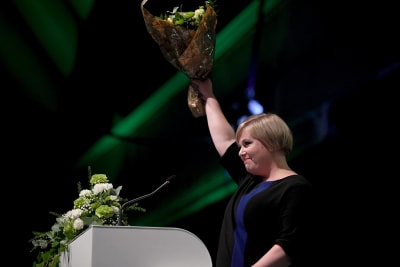 Kvinna bakom talarstol. Hon håller i en blombukett. Annika Saarikko i Uleåborg den 5 september efter att ha valts till Centerns ordförande.