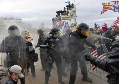 Poliser och Trumpanhängare utanför kongressbyggnaden i Washington den 6 januari 2021.