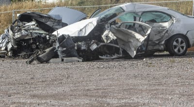 Två bilar som krockat på en sandväg, båda bilarna är rejält förstörda.