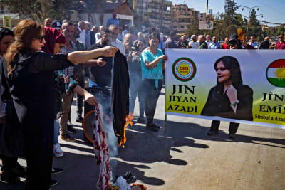Demonstranter bränner huvuddukar under en solidaritetsprotest organiserad av en syrisk-kurdisk gruppering.  Demonstration utanför FN:s kontor i staden Qamishli i Syriens nordöstra Hasakeh-provins den 10 oktober 2022.