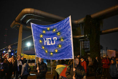 Demonstranter håller i en banderoll med EU-flaggan med texten "Hjälp" under en demonstration för oberoende nyheter i Ungern. 