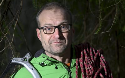 En man med en klättringshakka på axeln.
