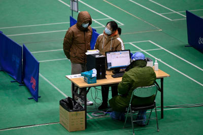 Människor får råd från läkare på en provisorisk feberklinik på stadion i Peking.