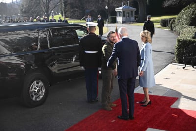 VOlodymyr Zelenskyj skakar hand med Joe Biden och hans fru på en röd matta framför en limousin.