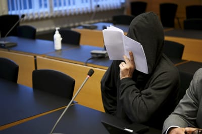 Mika Moring peittää kasvonsa paperiarkilla käräjäoikeudessa.