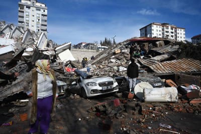 Människor betraktar de förstörda byggnaderna efter jordskalvet.