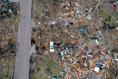 Drönarbild visar högar av skräp kvar där husen en gång stod före tornadon svepte fram.