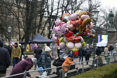 Ballongförsäljare och varmt klädda människor i Esplanadparken i Helsingfors.