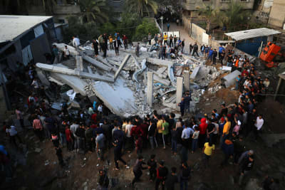 Palestinier inspekterar spillrorna av ett hus efter att det träffats i ett israeliskt flyganfall i Gaza den 13 maj 2023.  