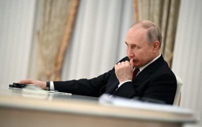 Vladimir Putin sitter vid ett bord.