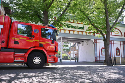 En brandbil står utanför en stängd port till nöjesparken Gröna Lund.