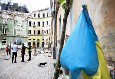 Poliisit seisovat vaurioituneen kerrostalon edustalla.