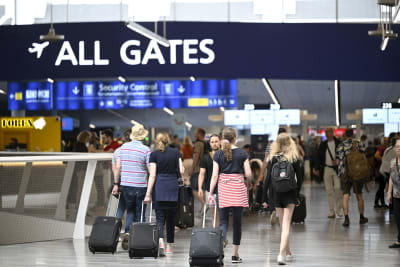 Passagerare på väg mot sin gate på en flygplats.