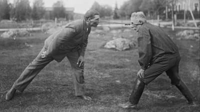 Två män leker leken "dra pissmyra". Bilden är tagen 1930 i Närpes, Kalaks.