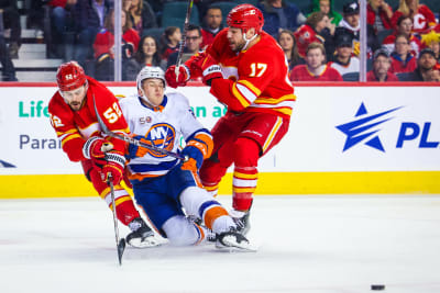 Mackenzie Weegar and Milan Lucic tackle an opponent.