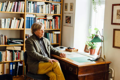 Författaren och filosofen Fredrik Lång sitter vid ett skrivbord.