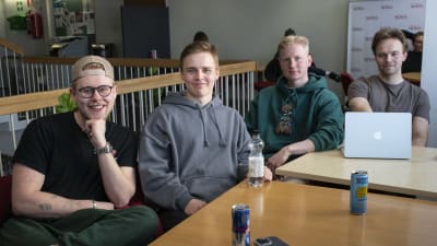 Fyra unga killar kring ett bord.