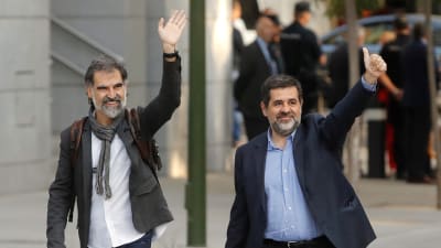 Jordi Cuixart (till vänster) som leder organisationen Omnium och ledaren för ANC, Jordi Sanchez, vinkade utanför Spaniens högsta brottmålsdomstol i Madrid innan de häktades. 
