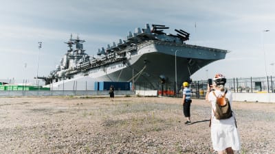 Ihmisiä katsomassa USS Kearsargea Hernesaaren rannassa.