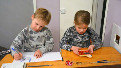 Två barn sitter vid en gammal träpulpet. Pojken till vänster ritar medan flickan till höger räknar på en miniräknare.