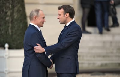 Putin och Macron skakar hand.