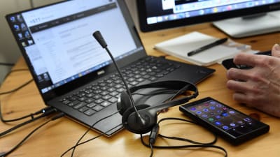 Bild av en dator, hörlurar och telefon. 