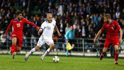 Teemu Pukki dribblar mellan två rödklädda fotbollsspelare.