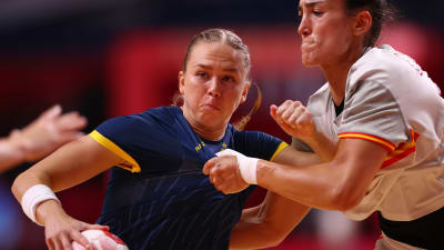 Sveriges Jenny Carlson håller i bollen och kämpar mot en motståndare i premiärmatchen mot Spanien i OS i Tokyo.