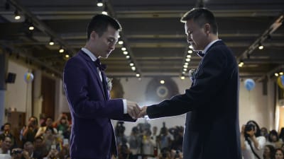 Sun Wenlin och Hu Mingliang byter ringar under deras bröllopsceremoni i Kina.
