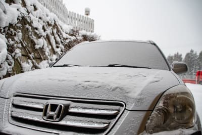 En parkerad personbil med snö på. 