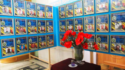 En minneshörna för stupade Charkivbor, tavlor med porträtt på de stupade och ett bord med ett ljus och blommor framför.