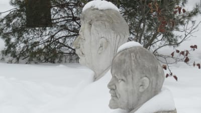 Statyer på Stalin och Lenin tittar fram ur snön i Moskvan.