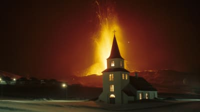 Ett vulkanutbrott bakom en kyrka på Island år 1973.