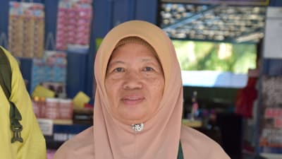  Rusnawati Shamsudin. En kvinna i Malaysien iklädd en beige/ljusröd burka.